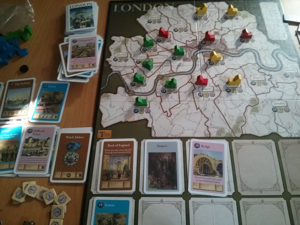 First-edition London mid-game: the city map with wooden buildings, rows of cards and loan tokens