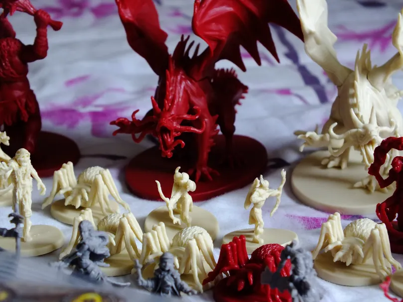 Descent hero and monster miniatures: heroes, cream creatures and red demons with a dragon · 1