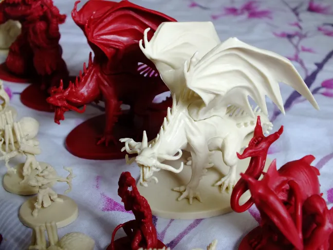 Descent hero and monster miniatures: heroes, cream creatures and red demons with a dragon · 3